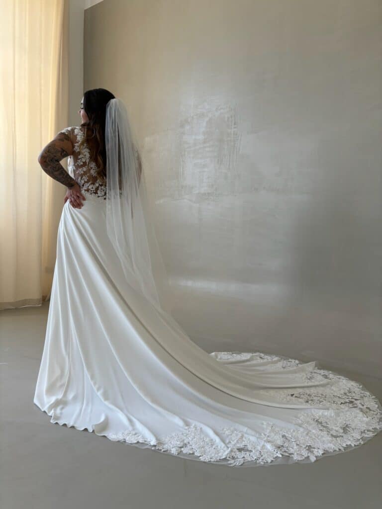 Entdecken Sie unser modernes A-Linien-Brautkleid aus leichtem Georgette und kristallbesetzter Spitze. Es besticht durch Kappa-Ärmel, einen eleganten V-Ausschnitt. vorne und einen abgerundeten Rücken. Perfekt für die stilbewusste Braut! Brautmodengeschäft, Brautkleid, Brautkleider