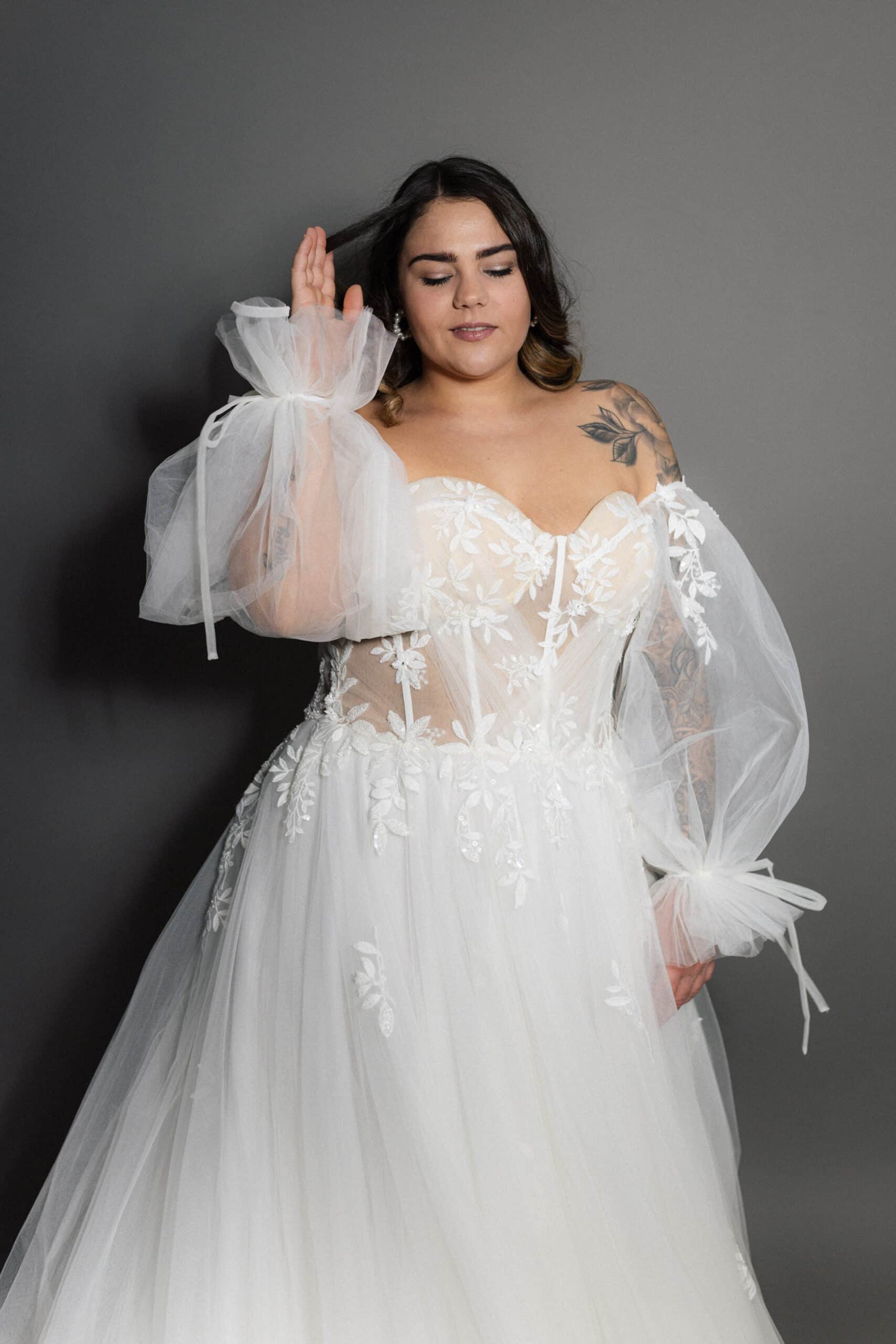 Unser romantisches A-Linien Brautkleid verzaubert mit exquisiter Spitze und weichem Tüll. Es besticht durch eine lange Schleppe, einen schmeichelhaften Herzausschnitt mit geradem Rücken und eine drapierte Korsage, die Ihre Silhouette perfekt hervorhebt. Brautmodengeschäft, Brautkleid, Brautkleider